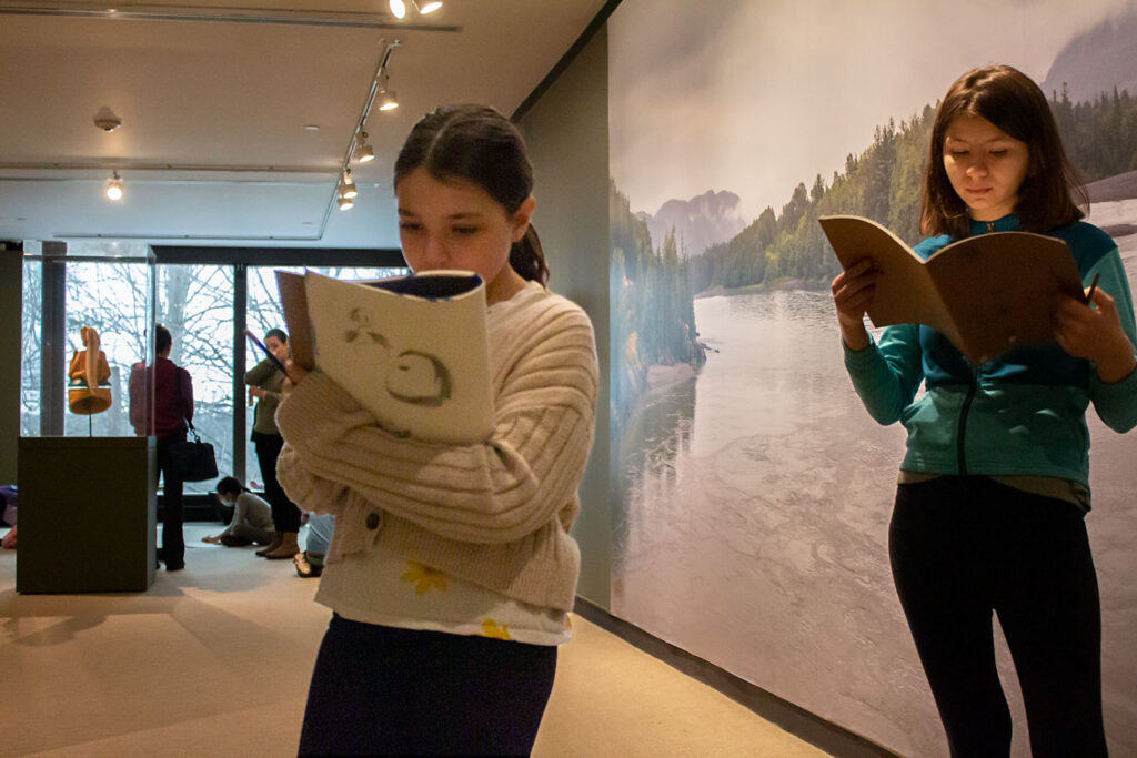 MBC_IMG_0224_WEB Children reading from books in a gallery space.