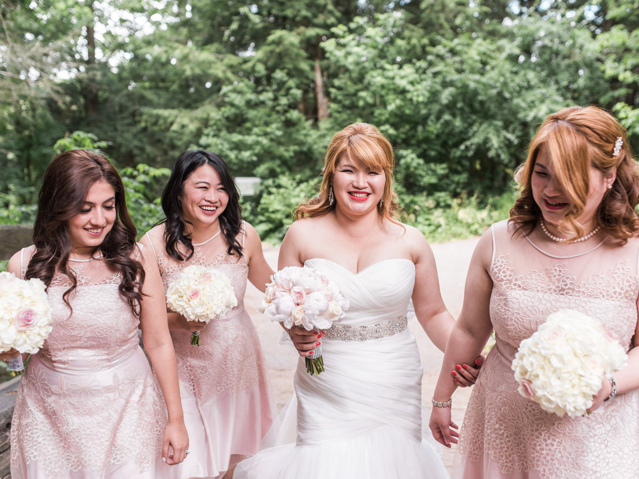 photograph of a bride and three adult bridesmaids in a woodland setting