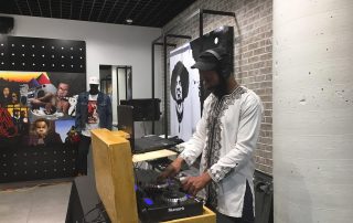 photo of a man playing records on turntables with graffiti-style art on the walls