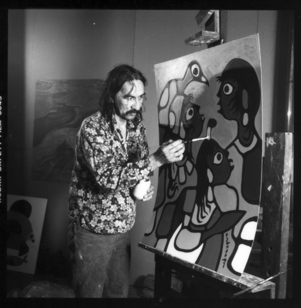 Norval Morrisseau, artist-in-residence in Thomson Shack 1979 black and white photograph of man painting on a canvas
