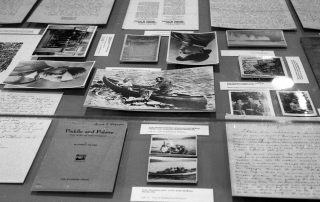 black and white photograph of documents, letters and books on a table