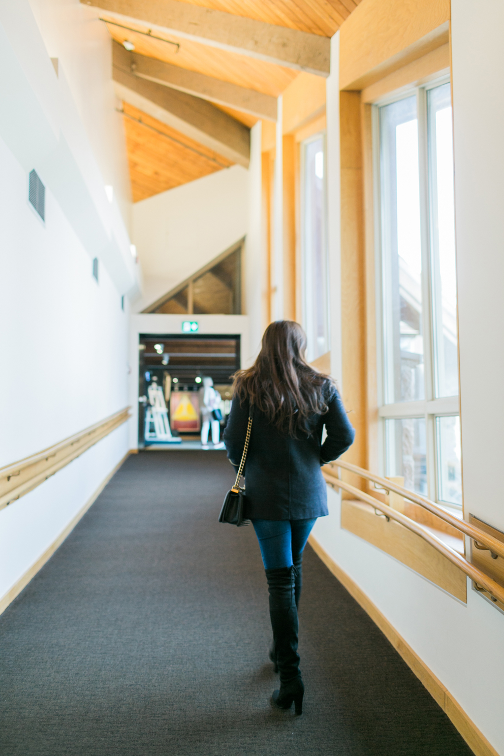 photograph of rear view of woman walking in hallway