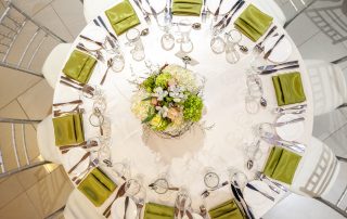 photo taken from above of round table set for dinner with floral centrepiece