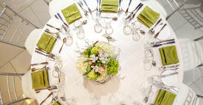 photograph taken from above of round table set for dinner with floral centrepiece